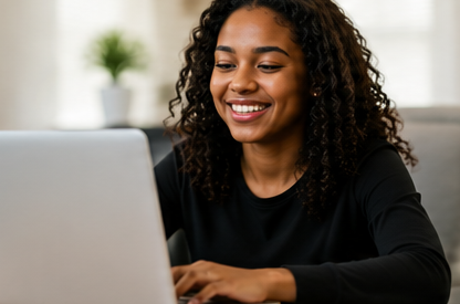 A girl smiling while working on her laptop